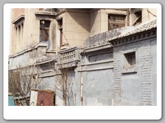 View of two-story buiding behind the street wall in the Hutong neighborhood